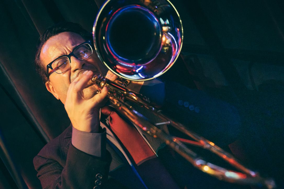 Guajirón trombonist performing under blue and red stage lights